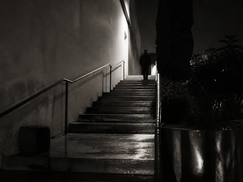 Black and white night photograph of a lit concrete stair
