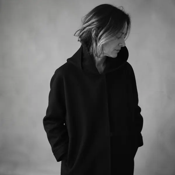 Studio portrait of a project manager in a dark hooded coat