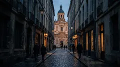 A narrow old city lane at dusk leading to an ornate domed building