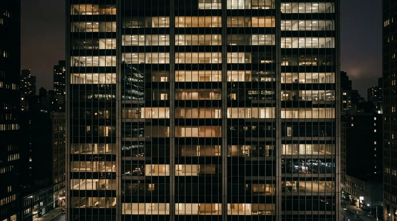 Glass office tower facade at night seen straight on