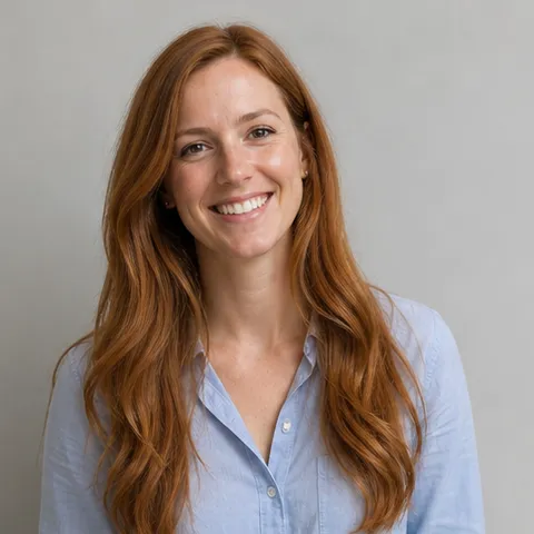 Smiling woman with long auburn hair in a pale blue shirt
