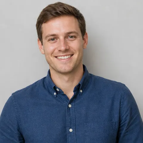 Smiling clean-shaven man with short brown hair in a navy shirt
