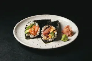 A cone shaped hand roll resting on a small white dish