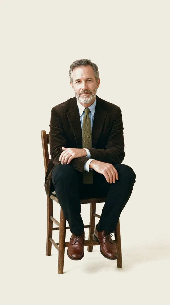 An illustrative client seated for a portrait