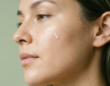 Close read of a client's cheek with one drop of serum on the skin