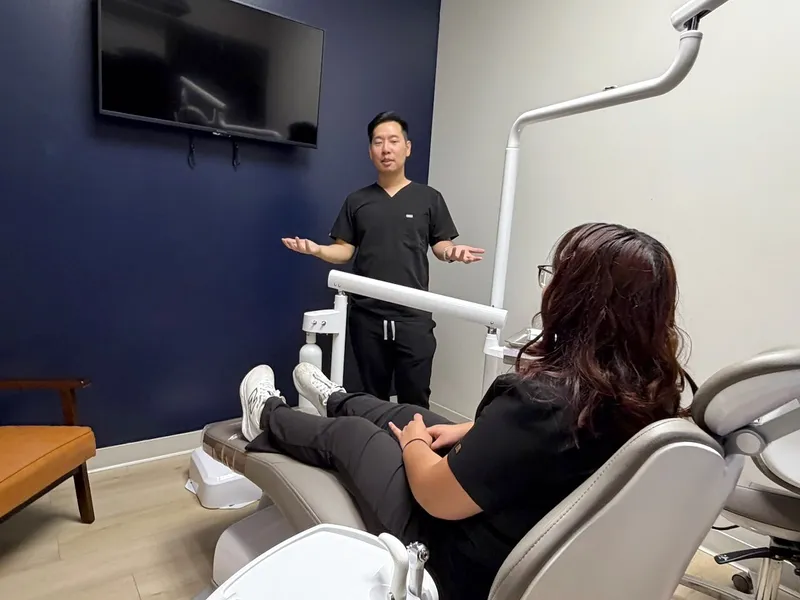 Dr. Tam talks with a patient in the treatment chair