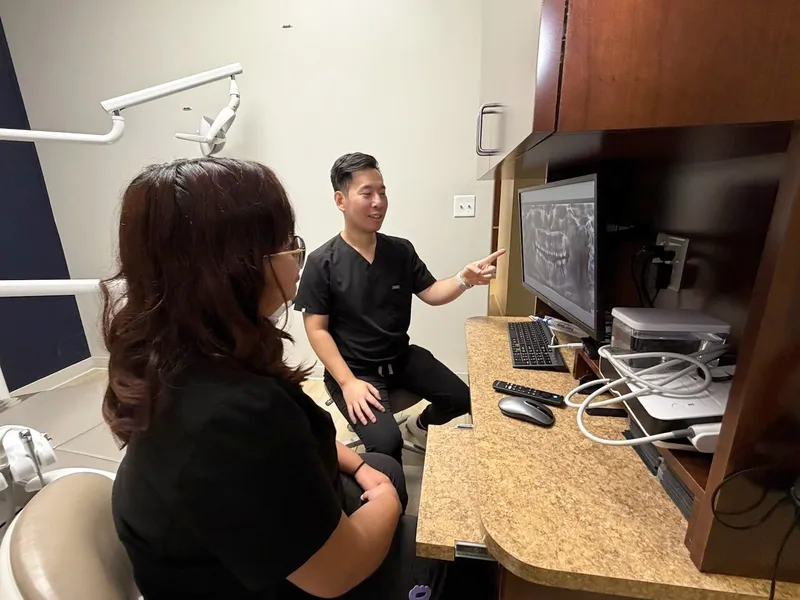 Dr. Tam talks a patient through her scan at the desk before any treatment