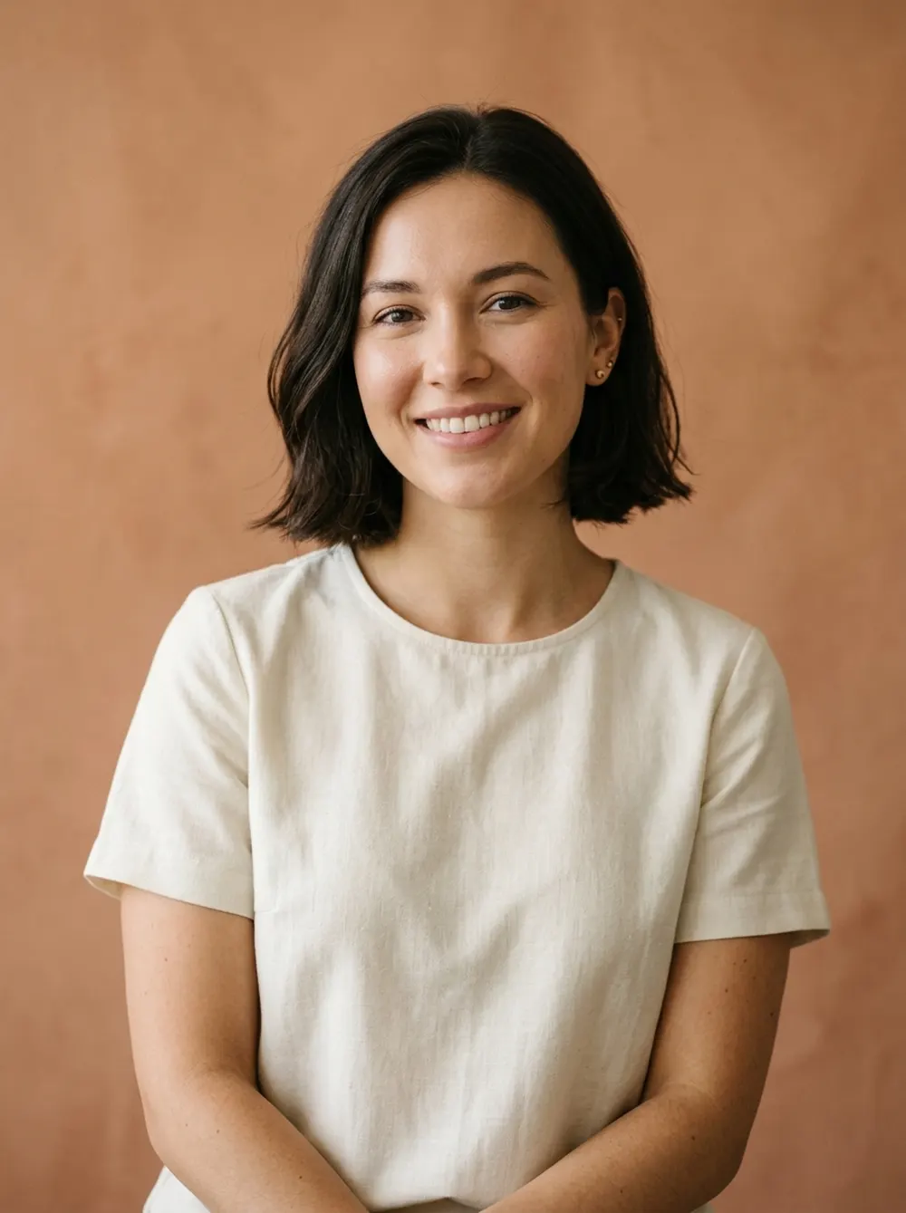 Reese Albright, licensed aesthetician, smiling in a cream tunic
