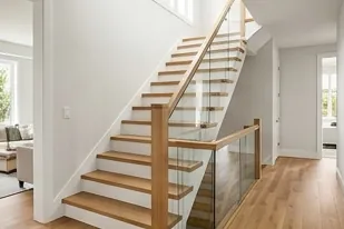 Stair hall with oak treads and glass rail