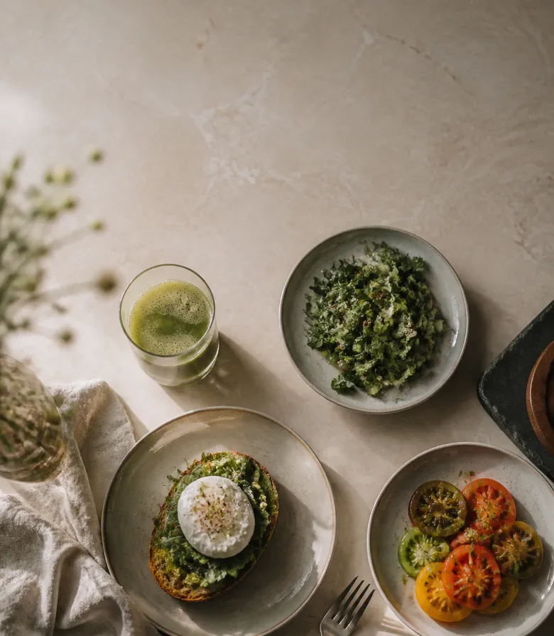 Breakfast plates and juice laid out on pale marble