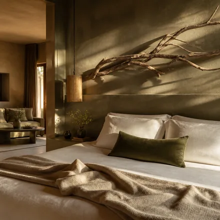 A plaster headboard wall with morning light raking across it.