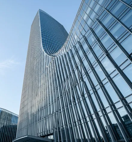 Curved glass office tower against a blue sky