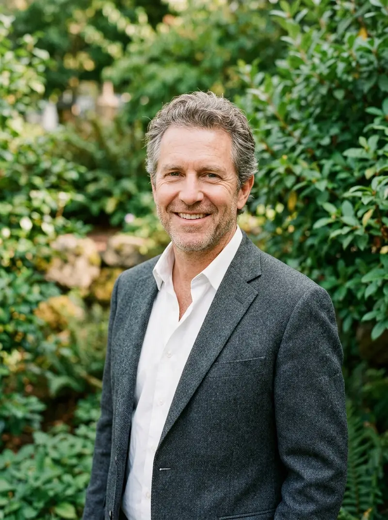 Portrait of executive director Daniel Whitcombe in front of green shrubs