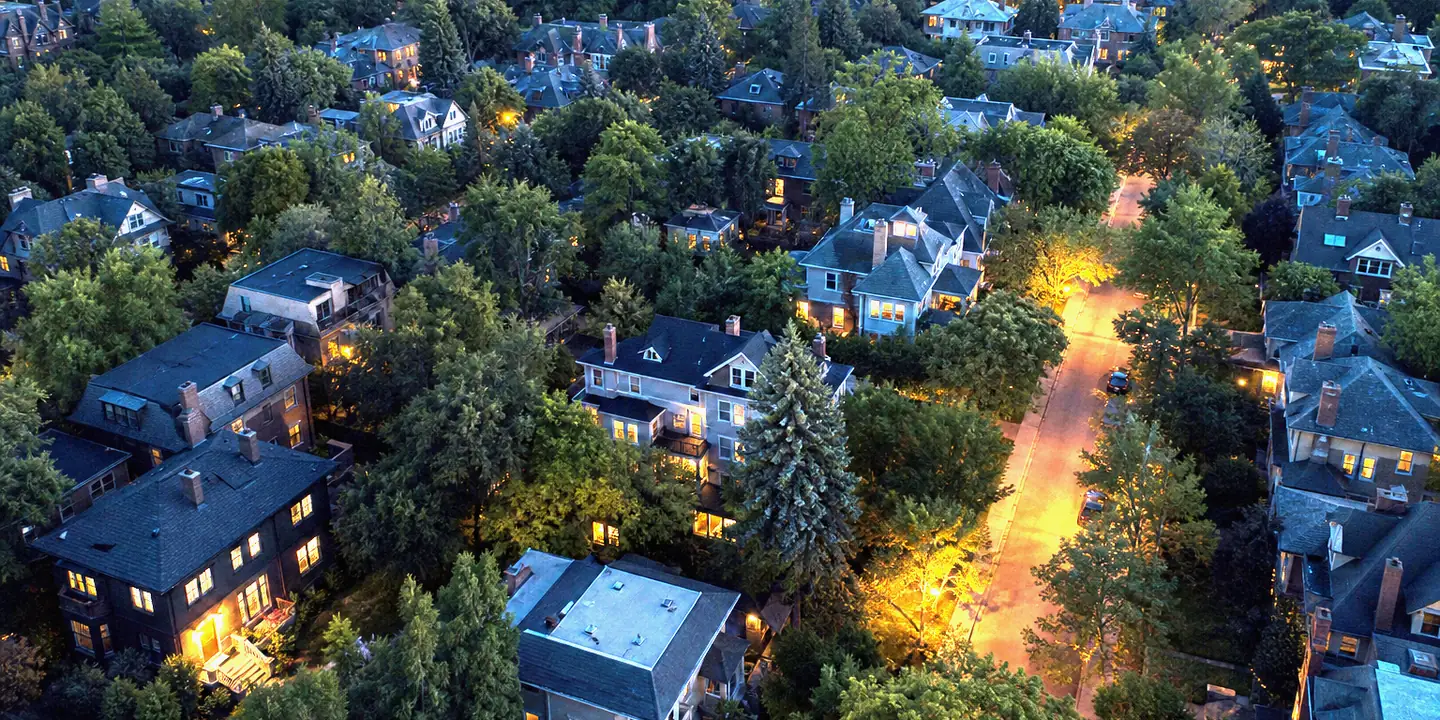 Aerial view of a leafy Brightwater neighbourhood at dusk with lit windows