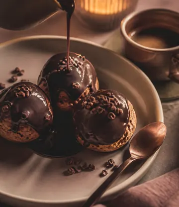 Three small chocolate puddings under a poured sauce