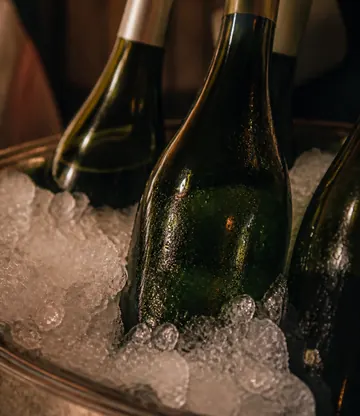 Green bottles set into a bucket of crushed ice