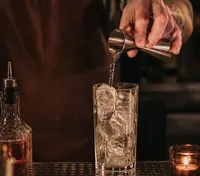A clear drink poured over ice