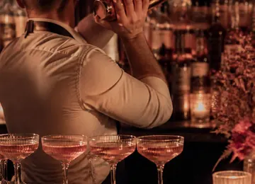 Coupe glasses lined along the marble counter before service