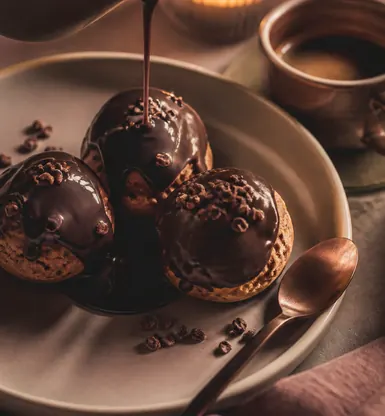 Three small chocolate puddings under a poured sauce