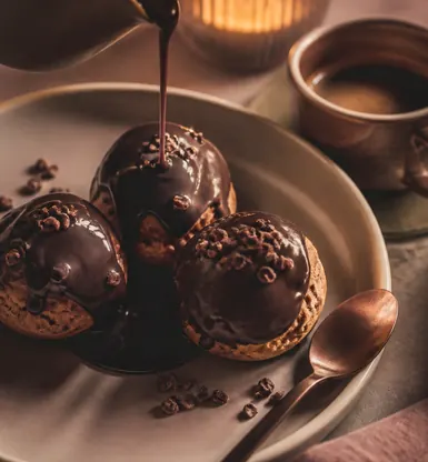 Three small chocolate puddings under a poured sauce