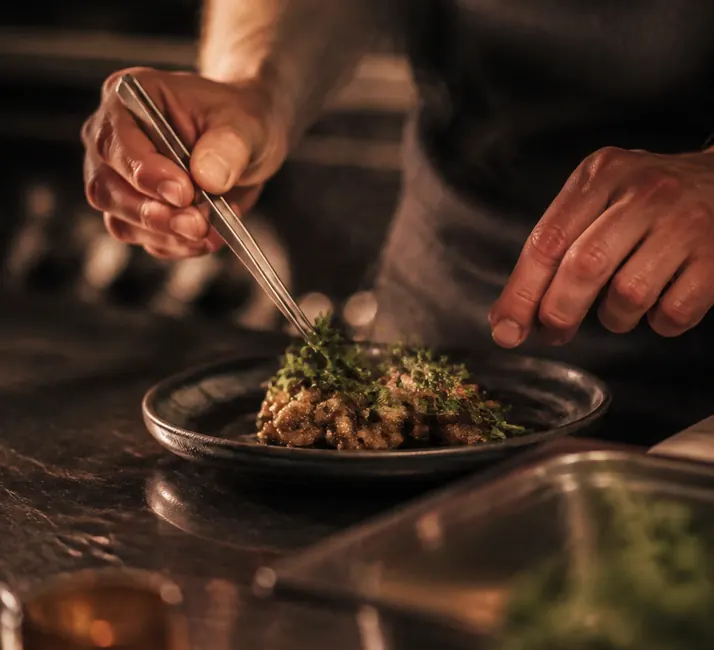 A cook working at the pass under the heat lamps