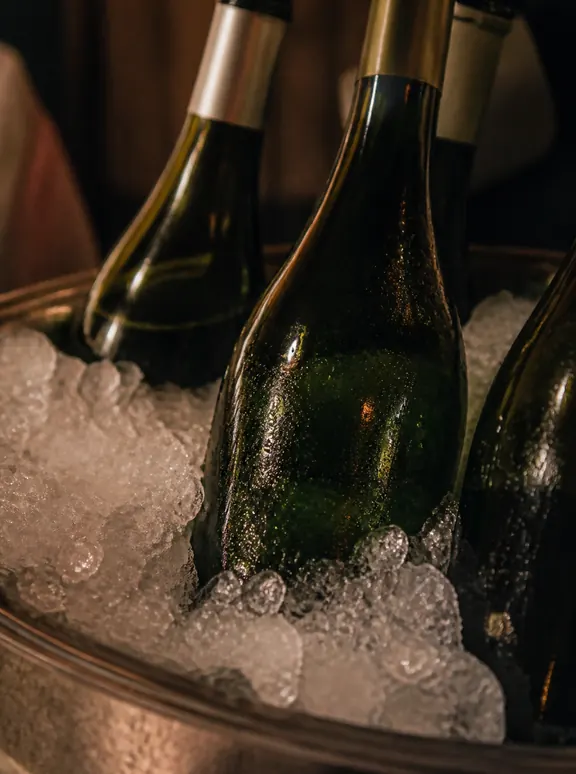 Bottles resting in crushed ice in a metal bucket