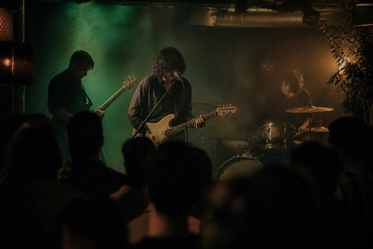 Three piece band on a small basement stage in coloured haze